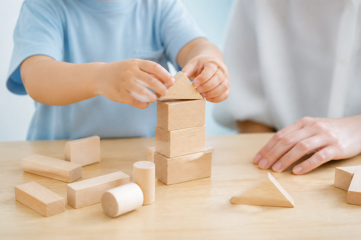 積み木をもう一度組み立てる子どもの手