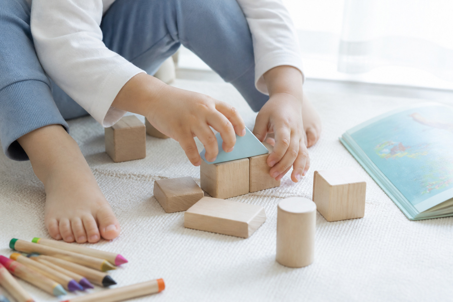 遊びに夢中になる子どもの手元と積み木