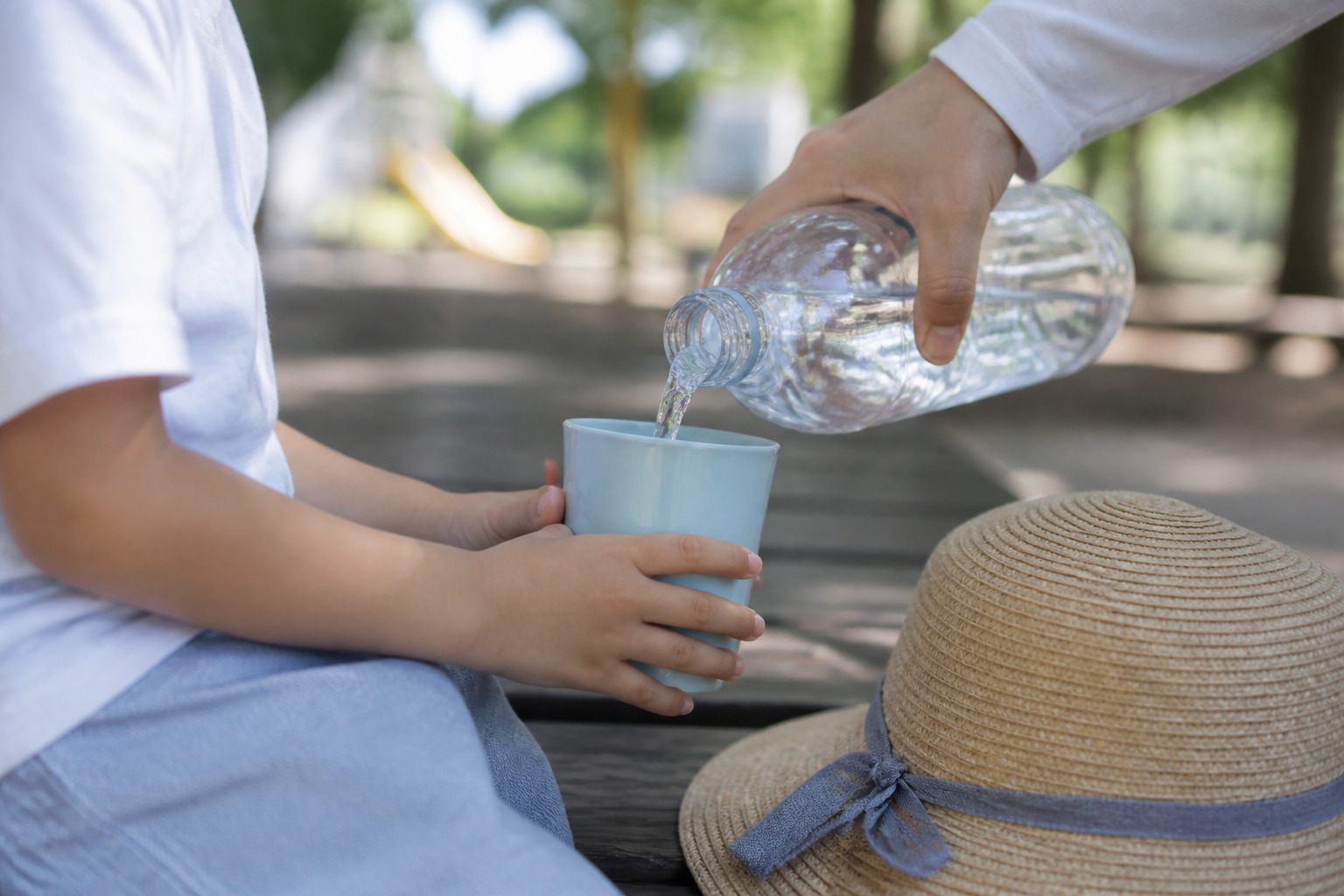 夏の公園で水分補給をする子ども